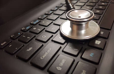 Close view of medical stethoscope on a laptop keyboard, concept of medical technology