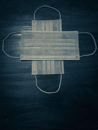 A pair of medical mask on a wooden table. Space for text.の写真素材
