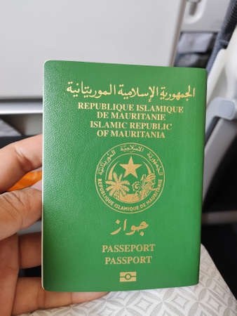 A man holding a passport of Islamic Republic of Mauritania. (Translation: Islamic Republic of Mauritania, Passport)のeditorial素材