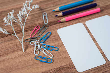 Wooden office table with different stationery, top view. Office worker workplace with pencils, paper, stapler and staplesの写真素材