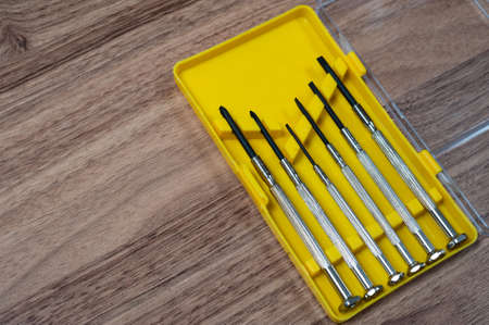 mini screwdriver set in a yellow box on the tableの写真素材