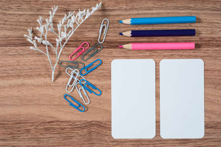 Wooden office table with different stationery, top view. Office worker workplace with pencils, paper, stapler and staplesの写真素材