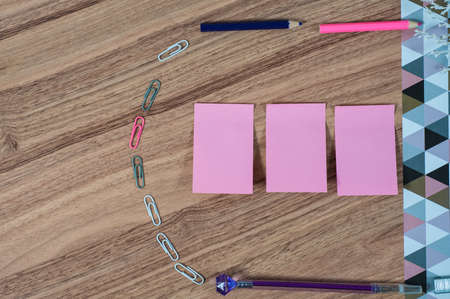 Wooden office table with different stationery, top view. Office worker workplace with pencils, paper, stapler and staplesの写真素材