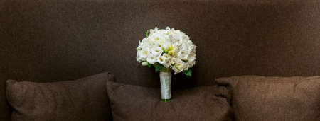 white wedding bouquet on the brown sofaの写真素材