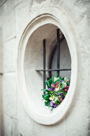 wedding bouquet in a stone box with a metal grateの写真素材