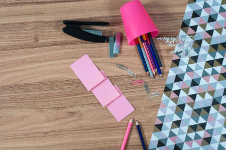 Wooden office table with different stationery, top view. Office worker workplace with pencils, paper, stapler and staplesの写真素材