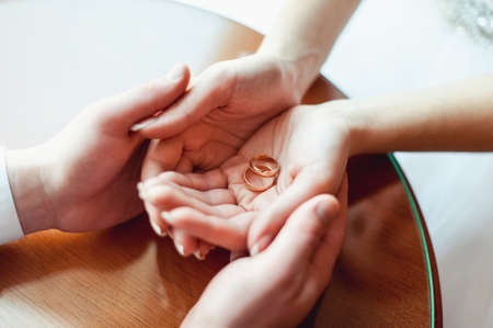 Wedding rings of gold in a hands of coupleの写真素材
