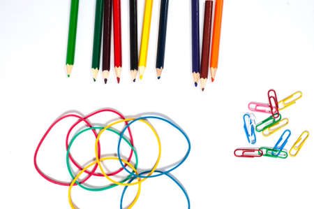 paper clip, color pencil and elastic on white paperの写真素材