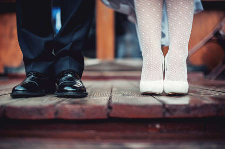 feet of bride and groom on the wooden floor, wedding shoes. vintage lookの写真素材