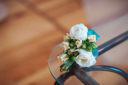 wedding Bouquet of white roses with a blue ribbon on the glass table in a roomの写真素材
