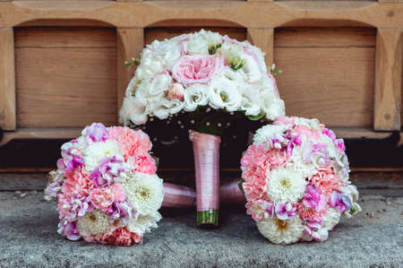 three wedding bouquets of white and biege roses on the floor.の写真素材