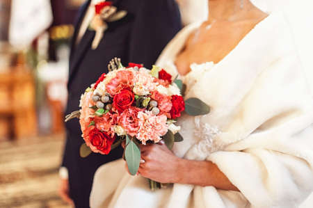 bride in a luxurious wedding dress holding a wedding bouquet made of rosesの写真素材