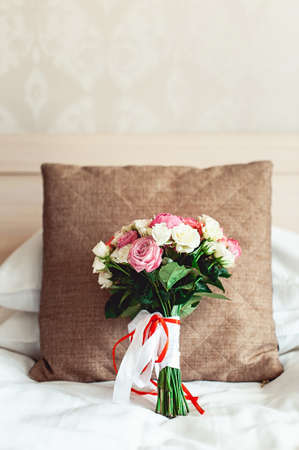 luxurious wedding bouquet on a white background on brown pillowの写真素材