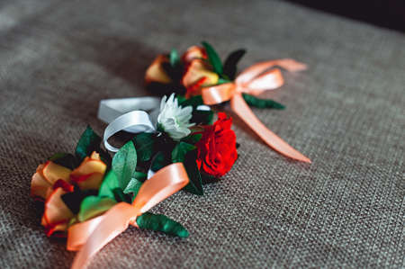 three little wedding boutonniere with roses with a ribbonの写真素材