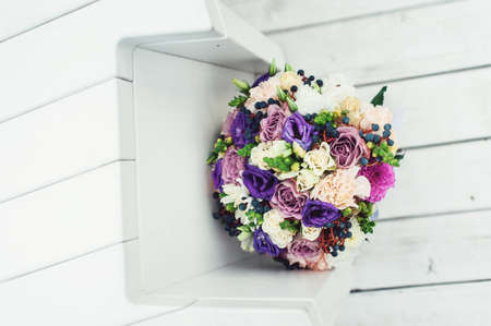 bridal bouquet of different flowers wrapped lace ribbon on a white backgroundの写真素材