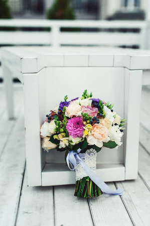bridal bouquet of different flowers wrapped lace ribbon on a white backgroundの写真素材