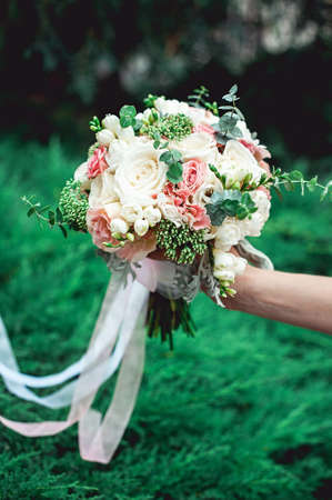 bride holding a wedding bouquet made of rosesの写真素材
