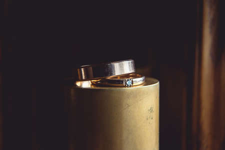 classic gold wedding rings on the top of golden coneの写真素材