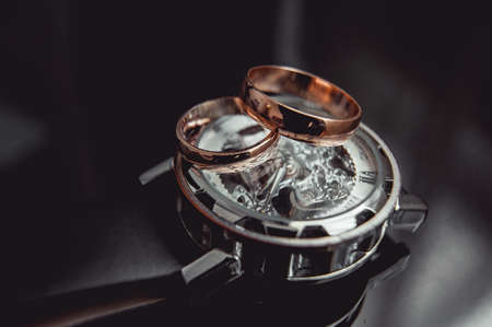 Classic gold wedding ring on a luxury watchの写真素材