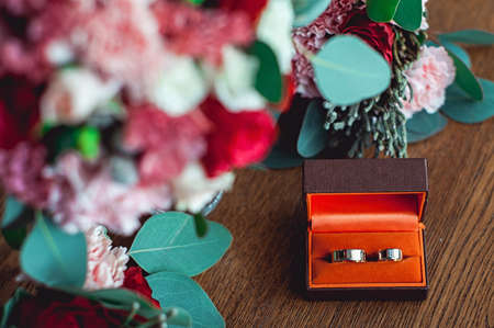 two golden wedding rings in a orange box