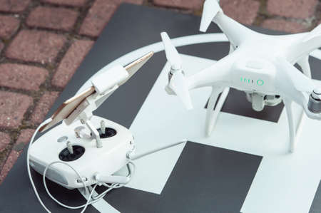 remote controller and quad copter on the helicopter landing spotの写真素材