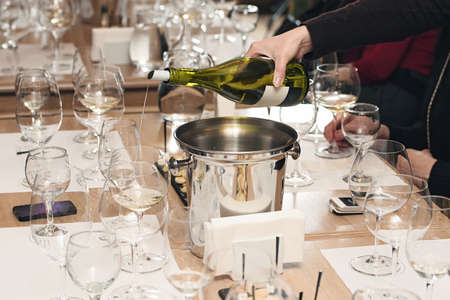 sommelier pouring wine into glass at wine tastingの写真素材