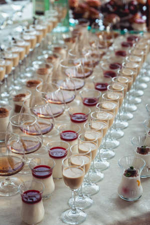 Beautiful row line of different colored alcohol cocktails on a party, Whisky cognac, liquor.の写真素材