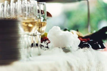 Beautiful row line of different colored alcohol cocktails on a party, Whisky cognac, liquor dry ice.の写真素材