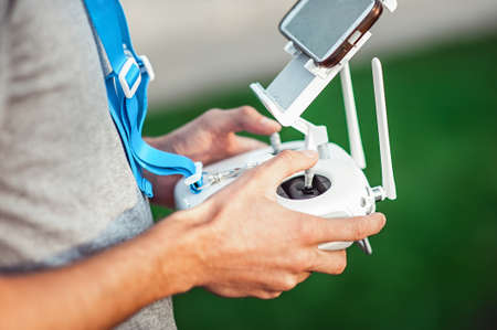 Drone remote control in hand of a man. Man operating of flying drone