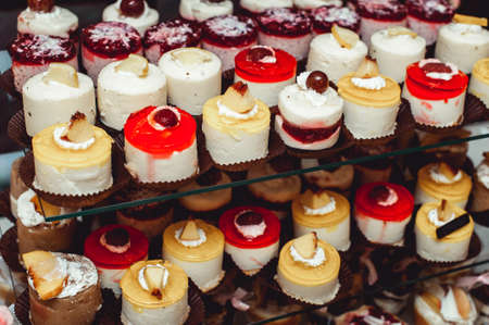 rows of italian mignon cakes on a glass standの写真素材