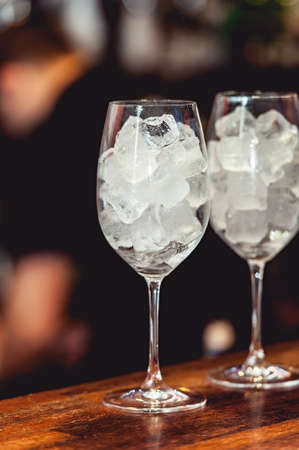 Bartender cooling out cocktail glass with iceの写真素材