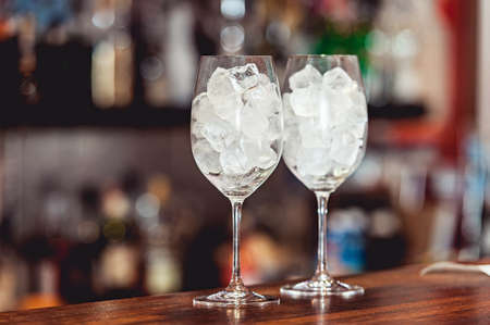 Bartender cooling out cocktail glass with iceの写真素材