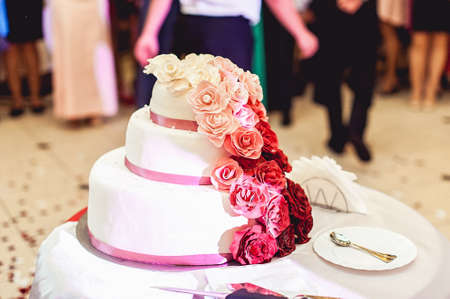 white red pink wedding cake with rosesの写真素材