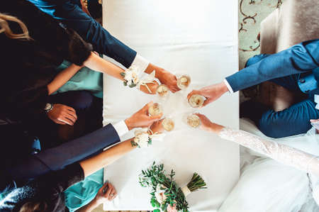 People hold in hands glasses with white wine. wedding party.の写真素材