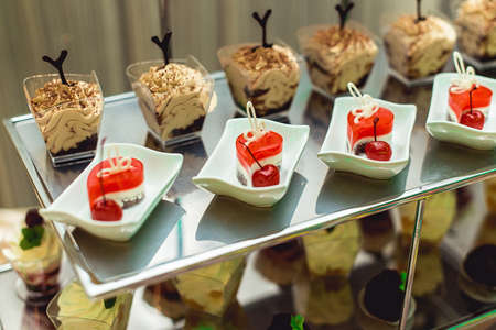rows of italian mignon cakes on a metal standの写真素材