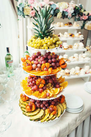 sliced fruits on a stand on a white tableの写真素材
