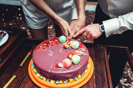 wedding ceremony. the bride and groom make their first case together, cutting the violet wedding cakeの写真素材