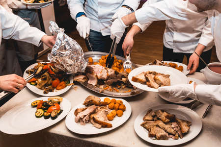 chef cuts roasted meat for restaurant guestsの写真素材