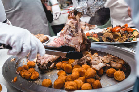 chef cuts roasted meat for restaurant guestsの写真素材