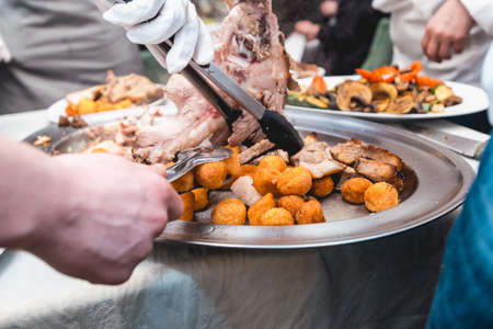 chef cuts roasted meat for restaurant guestsの写真素材