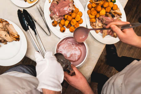 chef cuts roasted meat for restaurant guestsの写真素材