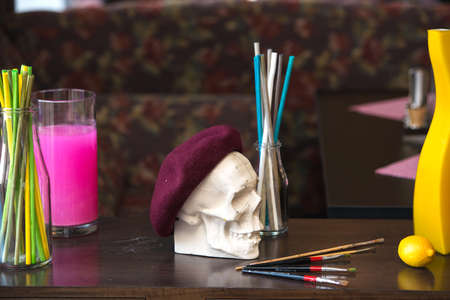 artistic atmosphere: vase with colored water, creative mood, skull in beret.の写真素材