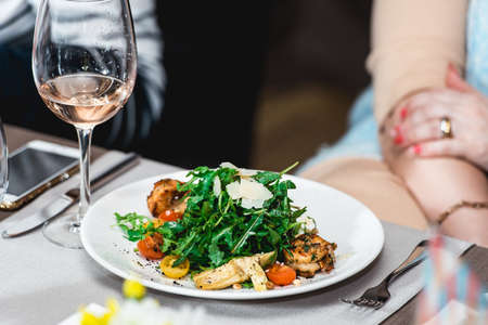 woman eating delicious salad with shrimp in a restaurantの写真素材