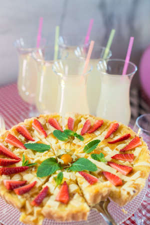 Whole round apple pie decorated with strawberry on a glass standの写真素材