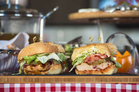 Fresh homemade burgers on wooden board in a restaurantの写真素材