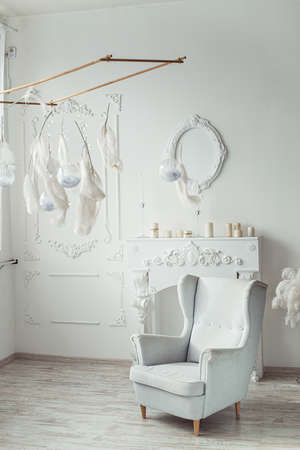white entrance area interior with fake Camino, vintage chair, decoration featherの写真素材