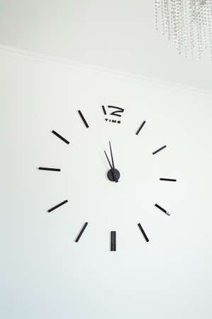 Frameless wall clock on white concrete wall. Minimalizmの写真素材