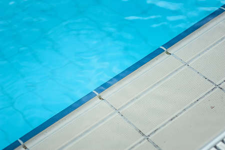 Swimming pool with clear blue water and white tiles. triangle form.の写真素材