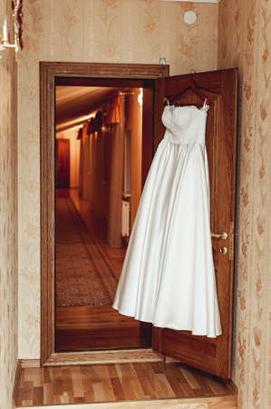 Wedding dress on a door in a hotel roomの写真素材