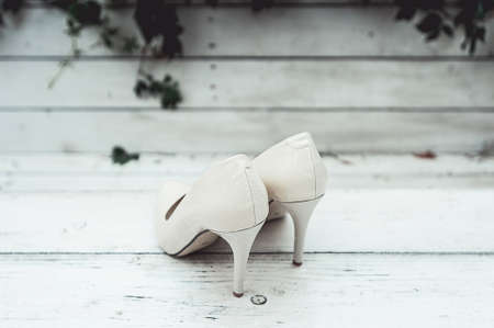 white wedding shoes in the rain on a white wooden tableの写真素材